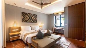 Ein modernes Hotelzimmer mit Bett, Nachttischen, Schreibtisch und Kleiderschrank.