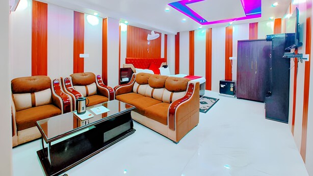 A modern living room with a sofa set, a coffee table, and a television. - Hotel Royal Castle Lucknow (Lucknow)