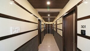 A hotel hallway with a modern design, featuring a central light fixture, a door with the number 301, and a light switch on the wall. - Hotel Royal Castle Lucknow (Lucknow)