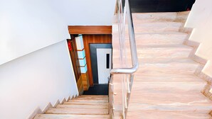 A marble staircase with a metal handrail leading to a door. - Hotel Royal Castle Lucknow (Lucknow)