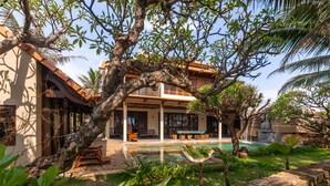 A house with a pool, outdoor seating, and lush greenery. - Sun Village Beach Resort (Hoa Hiep)