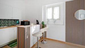 Eine moderne Küche mit Mikrowelle, Spüle und einem Barhocker.