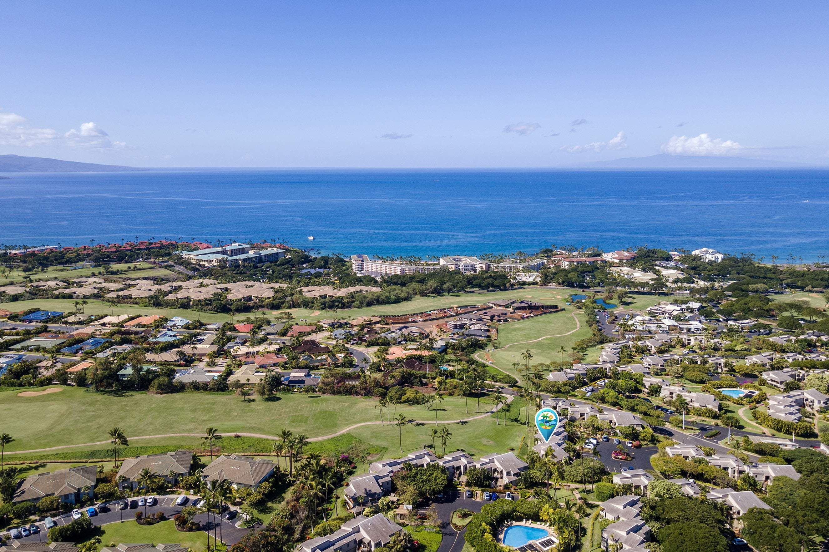 A coastal residential area with a golf course, a swimming pool, and a view of the ocean.