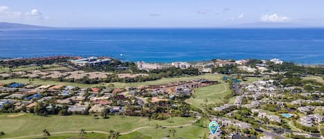 A coastal residential area with a golf course, a swimming pool, and a view of the ocean.