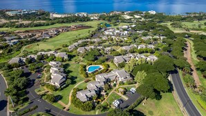 Vue aérienne d’un quartier résidentiel avec des maisons, un terrain de golf et une piscine.