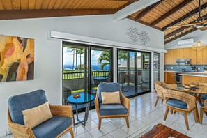 A modern interior with a kitchen, dining area, and a balcony with a view.