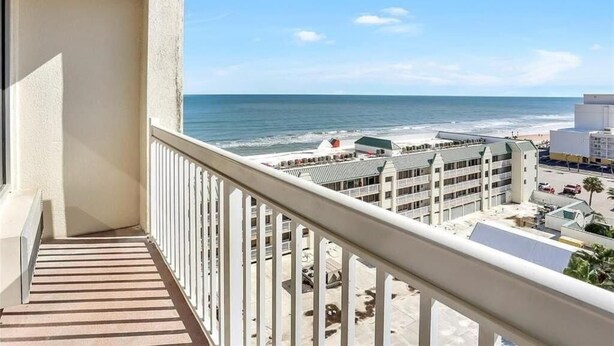 A balcony with a view of the beach and ocean. - Azure Tides Oceanfront (Daytona Beach)