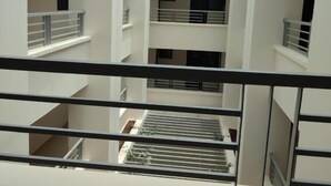 A multi-level atrium with a glass ceiling, white walls, and a central staircase. - Highland Rhinor (Eldoret)