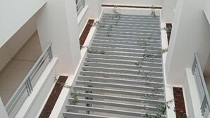 A multi-level building with white walls and balconies. - Highland Rhinor (Eldoret)