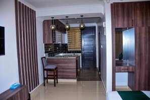 Superior studio suite, uitzicht op stad | Privékeuken | Een koelkast, een magnetron, kookgerei, borden en bestek
