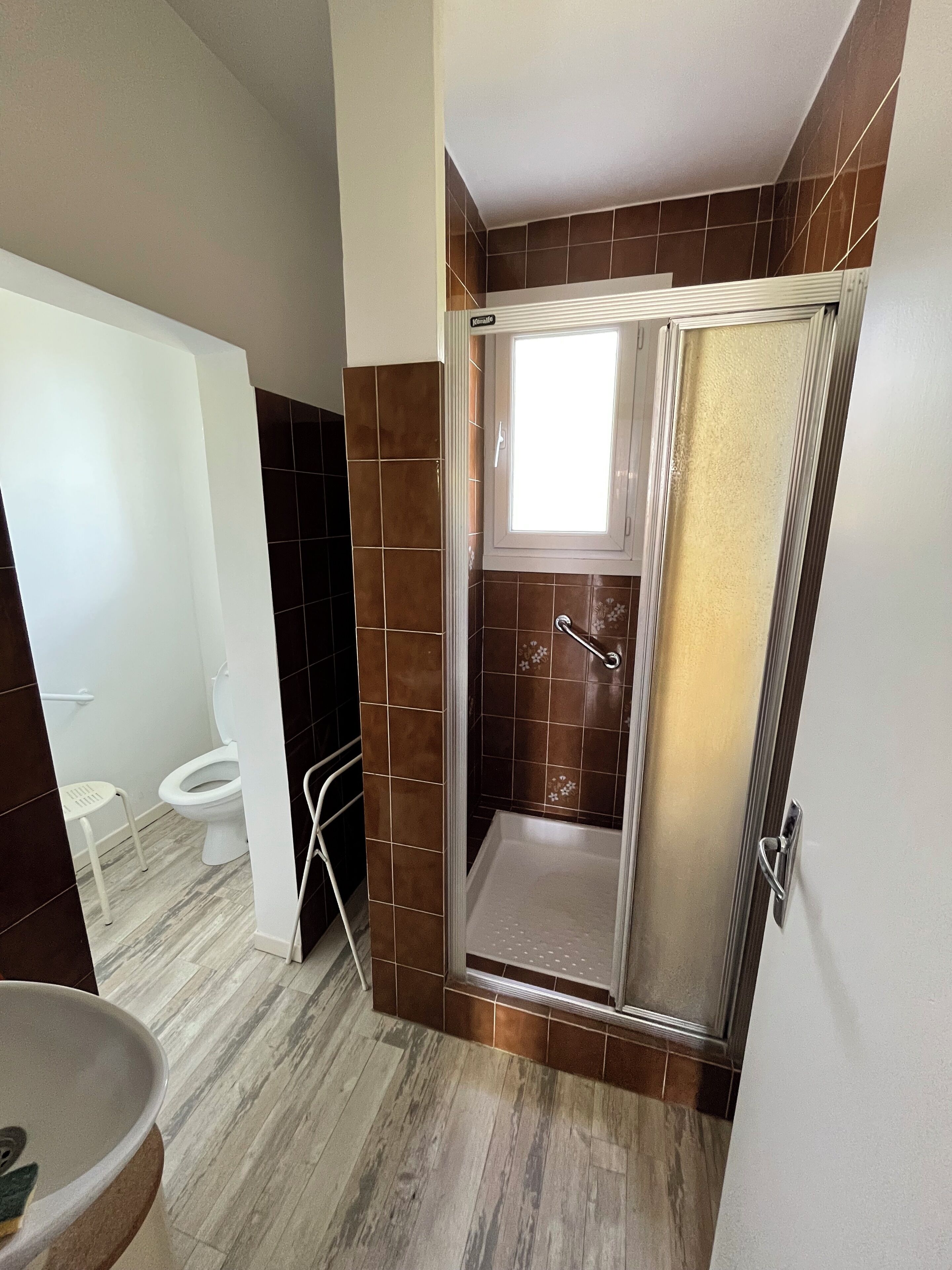 A bathroom with a shower, toilet, and sink.