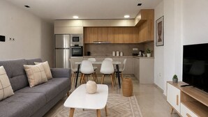 A modern living room with a grey sofa, a white coffee table, and a TV stand. - Spacieux 3 pieces a Kouba (Algiers)