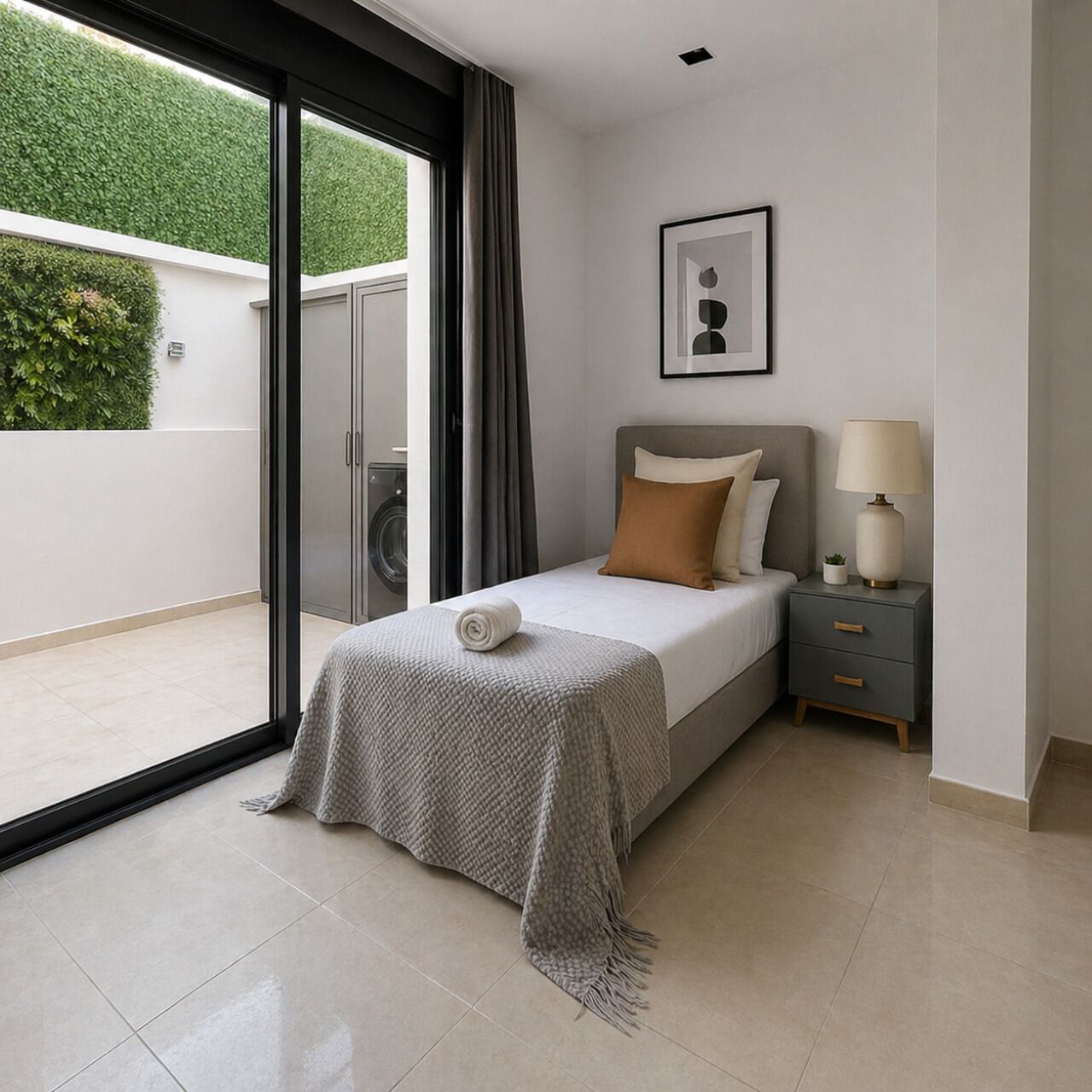 Un dormitorio moderno con cama, mesita de noche y vistas a un espacio exterior verde.