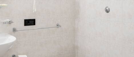 A bathroom with a toilet, bidet, sink, and a towel rack.