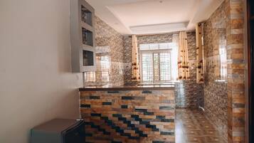 Una cocina con salpicadero de azulejos, refrigerador empotrado y una ventana con cortinas.
