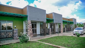 Uma fileira de edifícios modernos com telhado verde e um carro estacionado em frente.