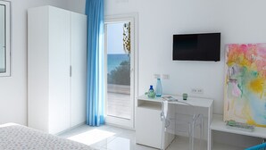 Een moderne hotelkamer met een bed, een bureau met stoel, een televisie en een schilderij.