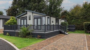 A mobile home with a front porch and a small staircase leading to the entrance.