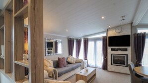 A modern living room with a sofa, coffee table, and a flat-screen TV mounted on the wall.