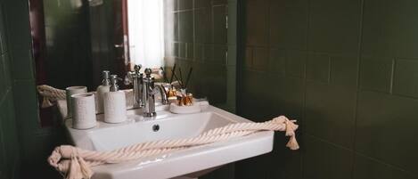 A bathroom with a white sink, a mirror, and a towel rack.