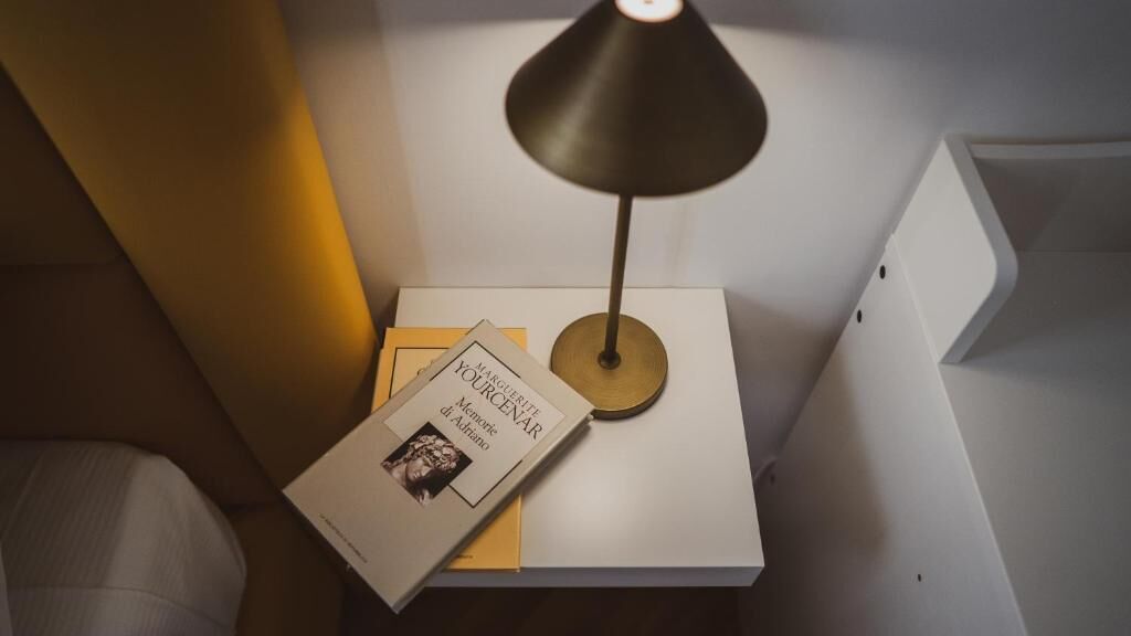 Ein Nachttisch mit Lampe, Buch und kleiner Schachtel.