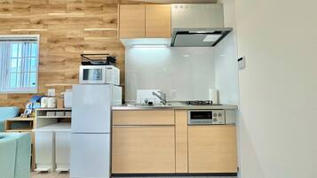 A compact kitchen with a microwave, refrigerator, sink, and oven.