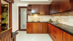 Una cocina moderna con armarios de madera, protector contra salpicaduras de piedra y encimera negra.