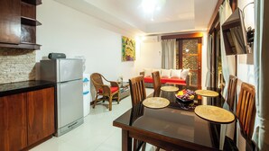 Un espacio habitable compacto con comedor, cocina y un conjunto de sofás.