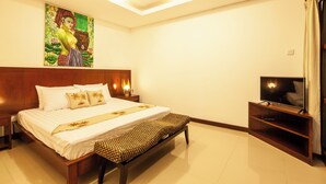 Un dormitorio con una cama, un banco, un televisor y un cuadro en la pared.