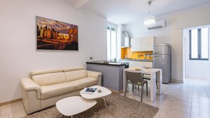 A modern apartment with a living area, kitchenette, and dining space. - Metro Università Apartment by Wonderful Italy (Naples)