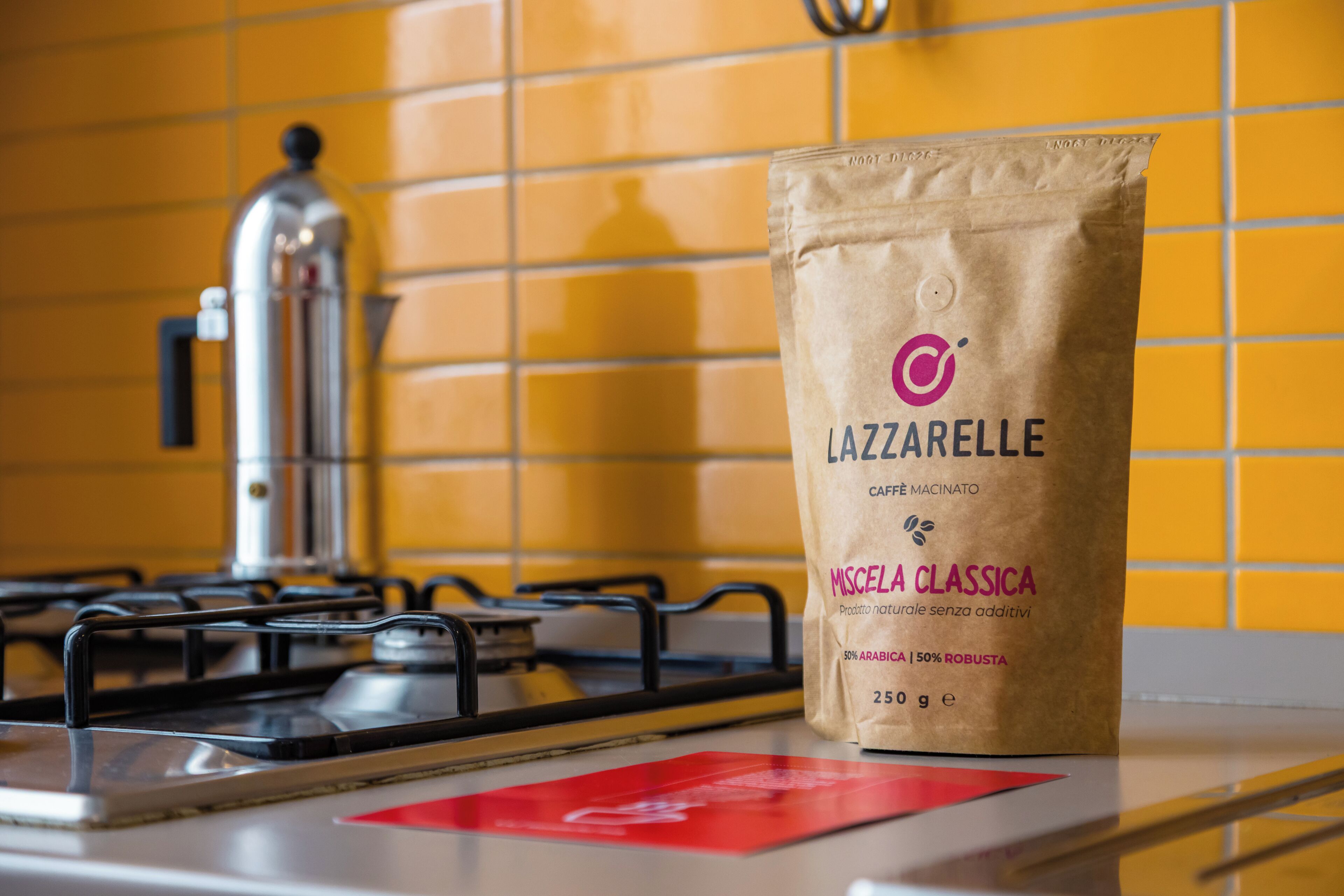 A bag of Lazzarelle coffee on a kitchen counter with a yellow tiled backsplash and a stove in the background.