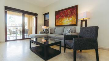 Departamento Deluxe, vista a la alberca | Área de sala de estar | Televisión de pantalla plana