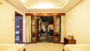 A hotel room with two beds, a small table, a lamp, and a view of a garden through a glass door. - 9BR Private Pool Sanur Beach Villa (3units villa) (Bali)