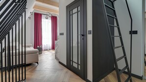 Un interior moderno con una escalera, un sofá y una puerta con un panel de vidrio.