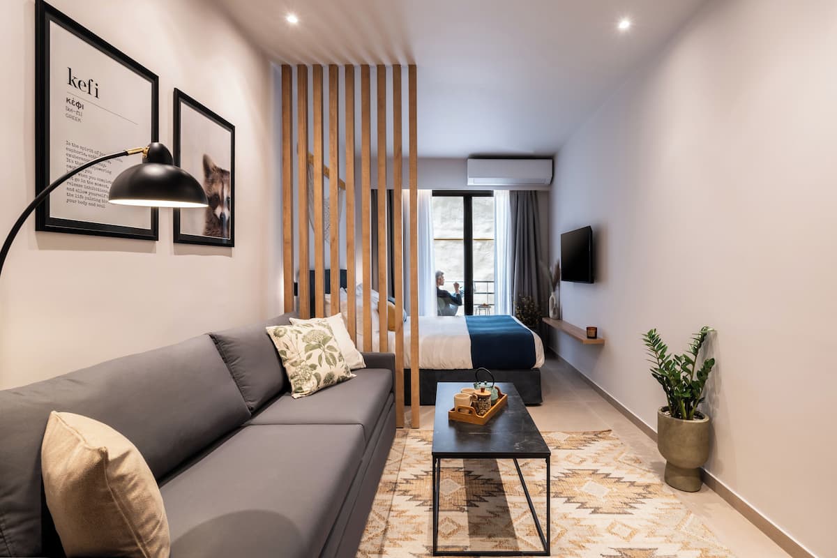 A modern living room with a sofa, a coffee table, a TV, and a plant.