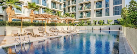Outdoor pool, pool umbrellas, sun loungers. GLOBALSTAY. The Elysee III Apartments