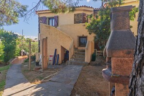 Une maison avec un escalier en pierre, un mur en pierre et une vue sur le paysage environnant.