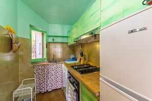 Une cuisine équipée d’un évier, d’une cuisinière et de placards.