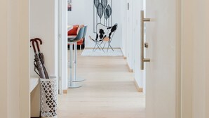 Un couloir qui mène à un espace repas, comprenant une chaise et une table au design moderne.