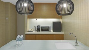 A modern bathroom with a sink, two pendant lights, a microwave, and a coffee maker. - Sunday Hotel Subang (Subang Jaya)