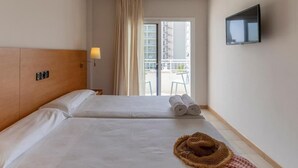A hotel room with two beds, a TV mounted on the wall, and a view of the outside balcony. - BAY HOTEL (Roses)