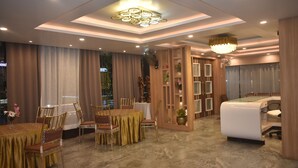Ein helles Esszimmer mit einem runden Tisch, Stühlen und einer Chandelüster.