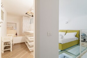 A bedroom with a bed, a bedside table, and a glass-enclosed area.