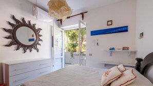 A bedroom with a bed, a dresser, a mirror, and a view of the outdoors. - Sea View Terrace - Santa Caterina di Nardò (Nardò)