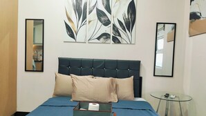 Ein Schlafzimmer mit einem Bett, einem Nachttisch, einem Spiegel und Bildern an der Wand.