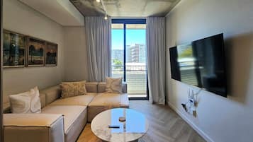 デラックス アパートメント | リビング エリア | 50 インチのスマートテレビ (衛星放送視聴可)、Netflix、ストリーミングサービス