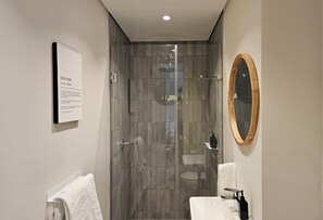 Deluxe appartement | Badkamer | Een douche, een haardroger, handdoeken, zeep