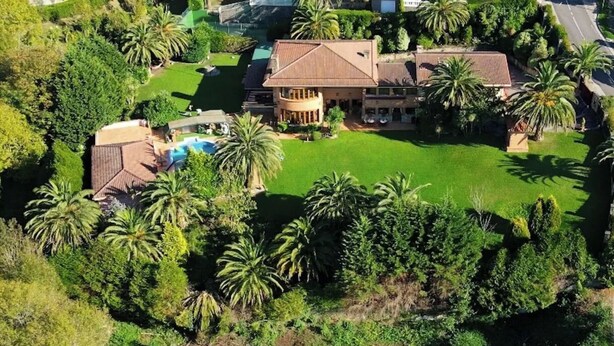 A large house with a swimming pool, surrounded by palm trees and greenery. - Royal Suite (Mungia)