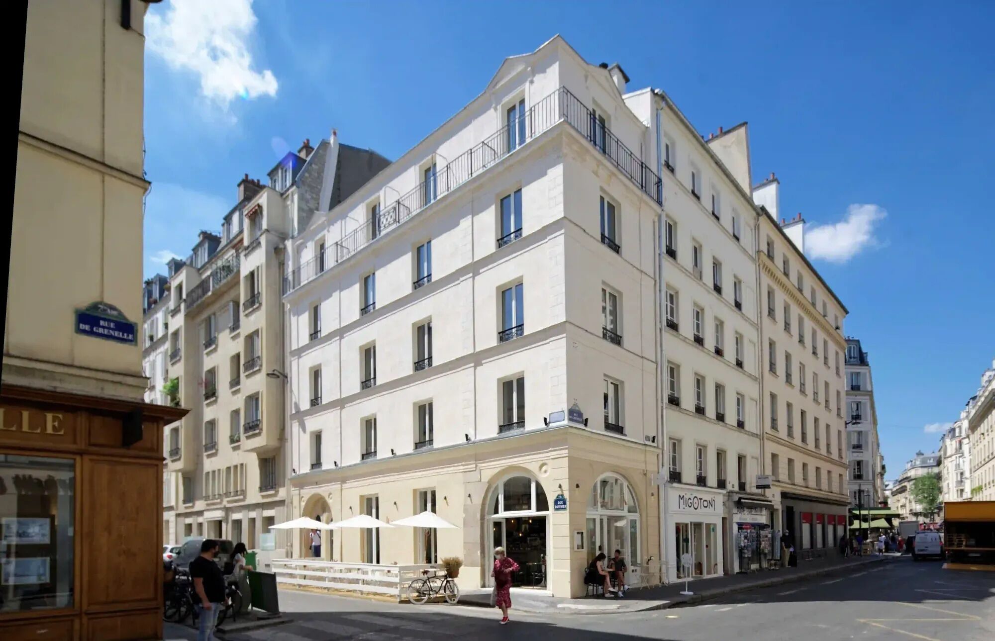 Un immeuble à plusieurs étages, de style architectural classique, doté de balcons et de grandes fenêtres.