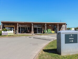 A building with 'Entrance' and 'Exit' signs, a sign for 'Marina,' and a sign indicating 'Additional Parking.'